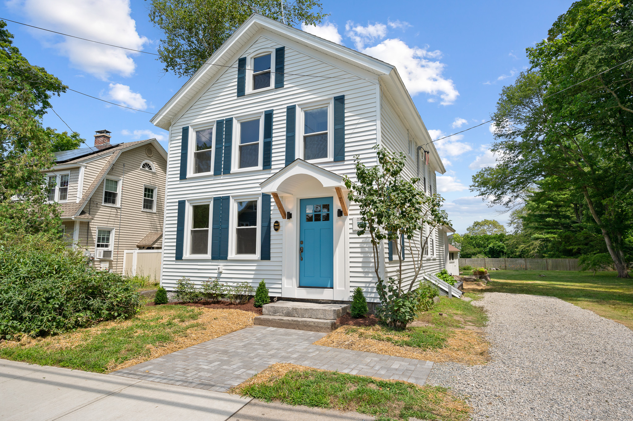 a front view of a house with a yard and potted plants