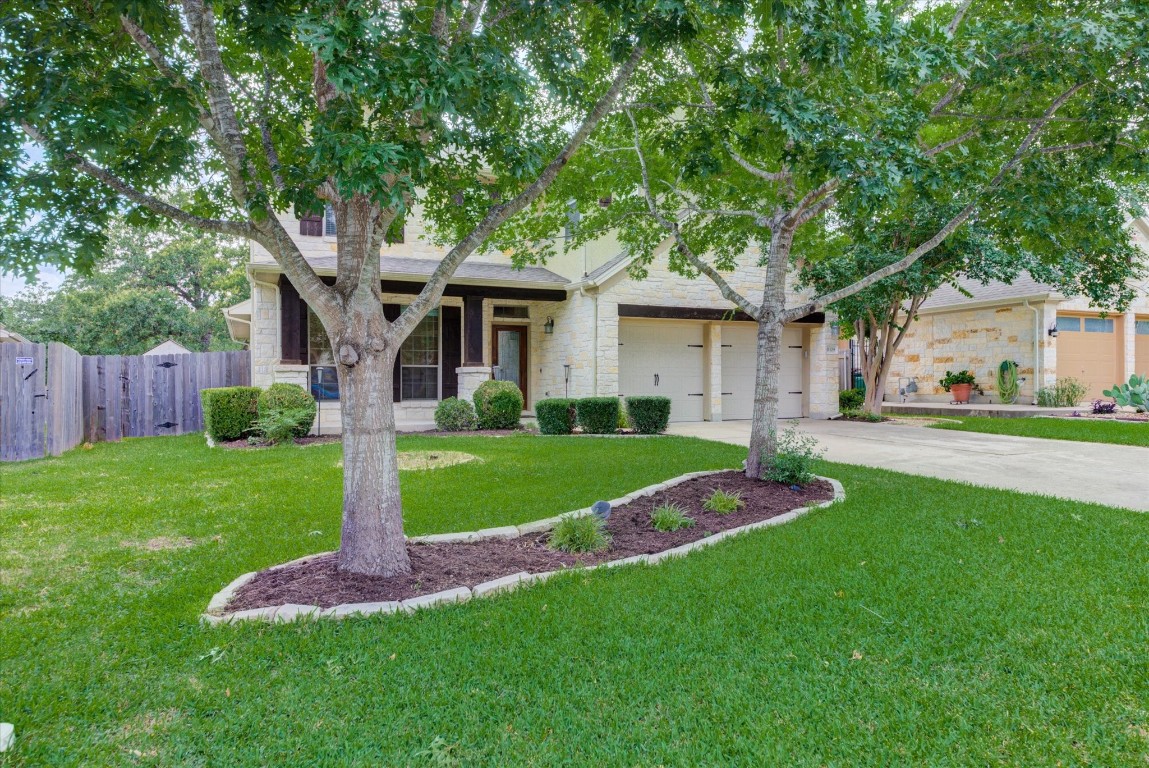 a front view of a house with a garden and trees