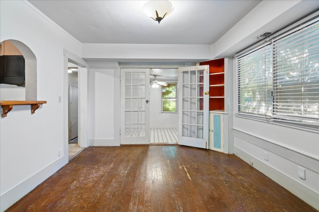 a view of empty room with wooden floor and fan