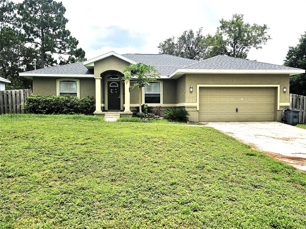 a front view of a house with yard and trees