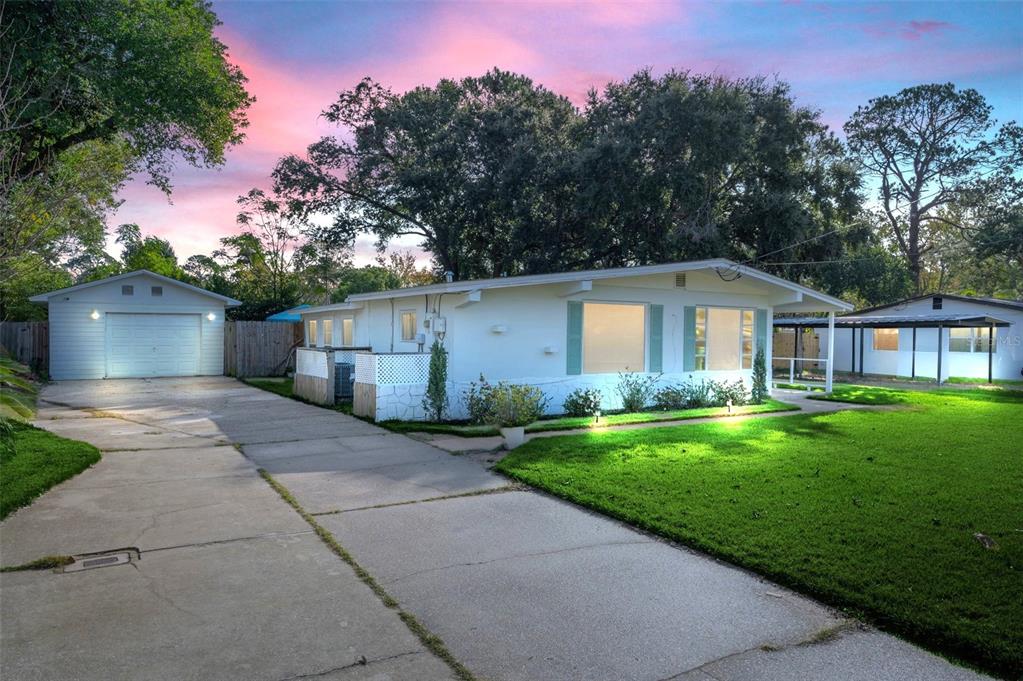 a front view of a house with a yard and trees