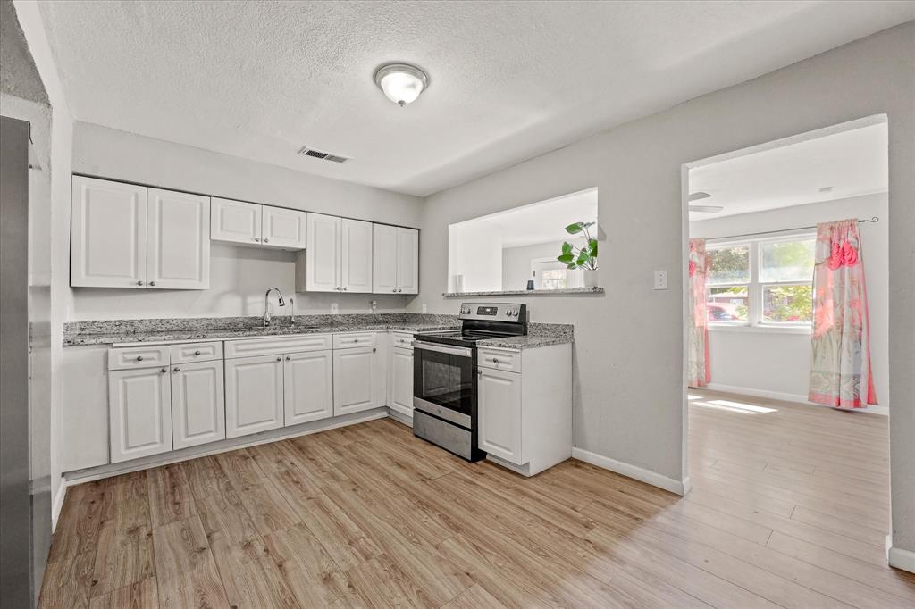 a kitchen with granite countertop white cabinets and white appliances