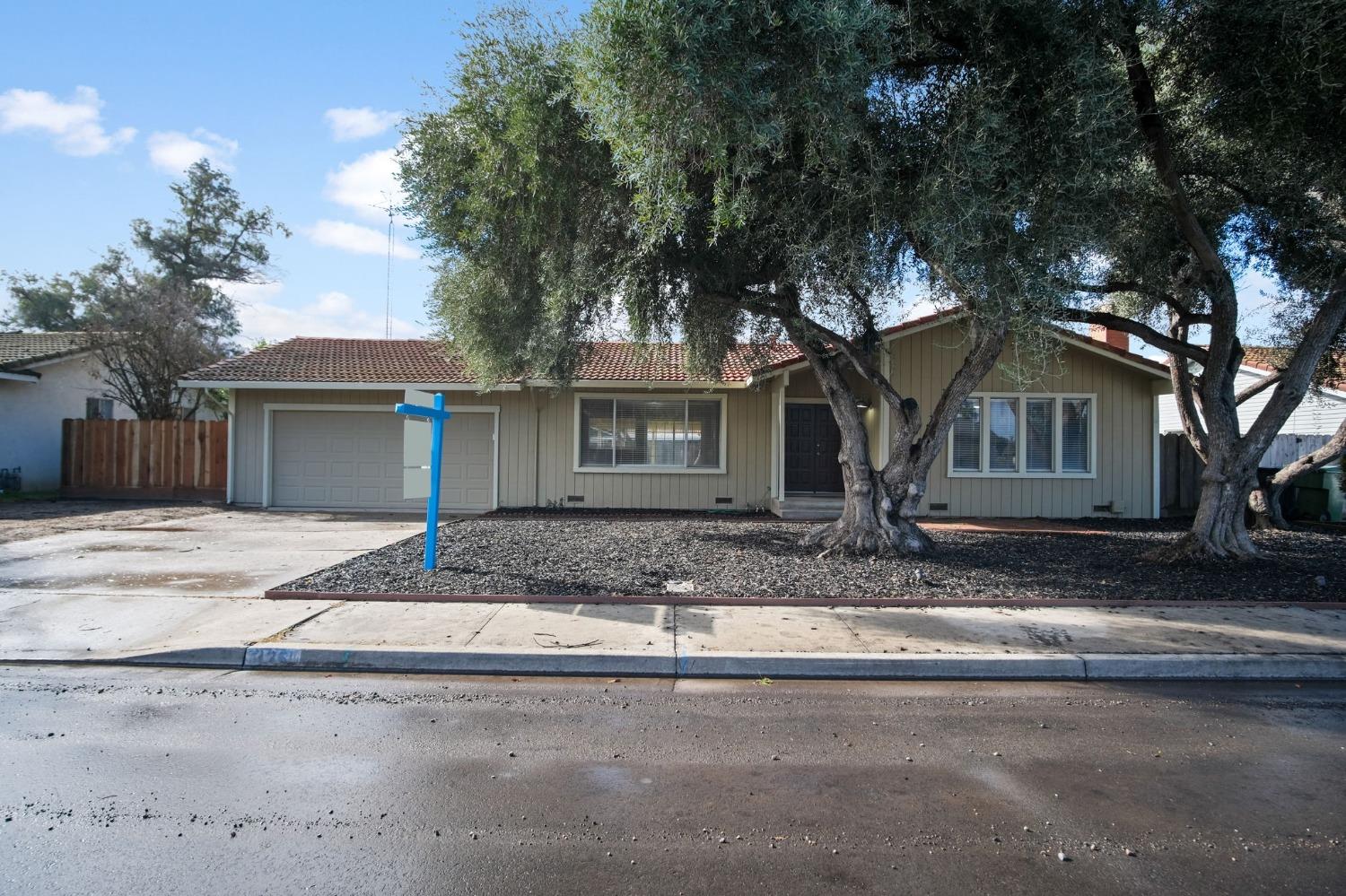 a front view of a house with a tree