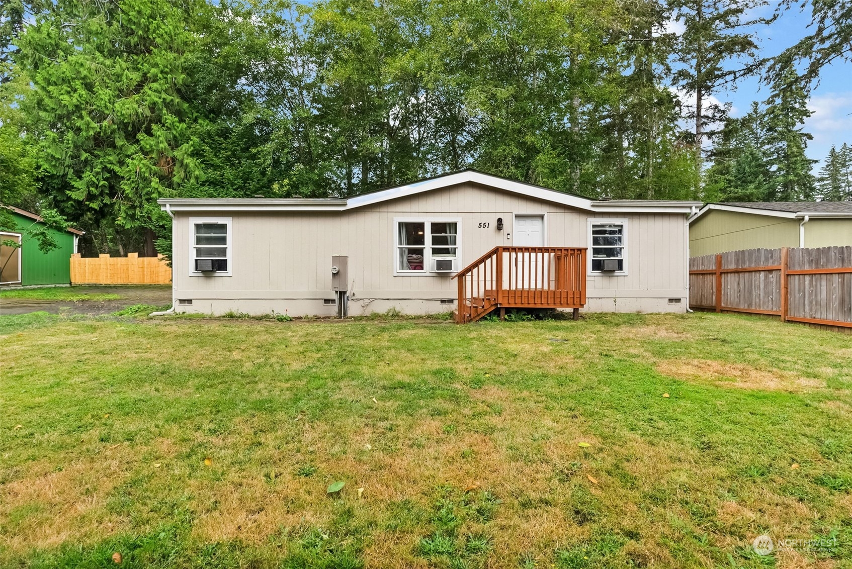 a view of a house with a yard and a large tree