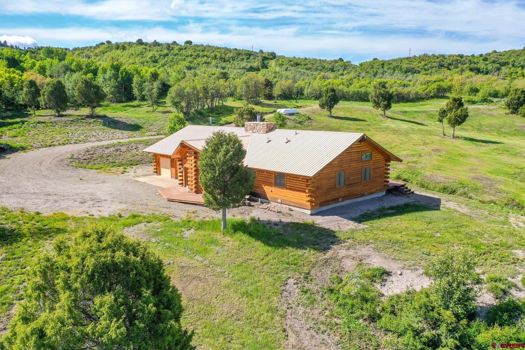 an aerial view of a house with yard and green space