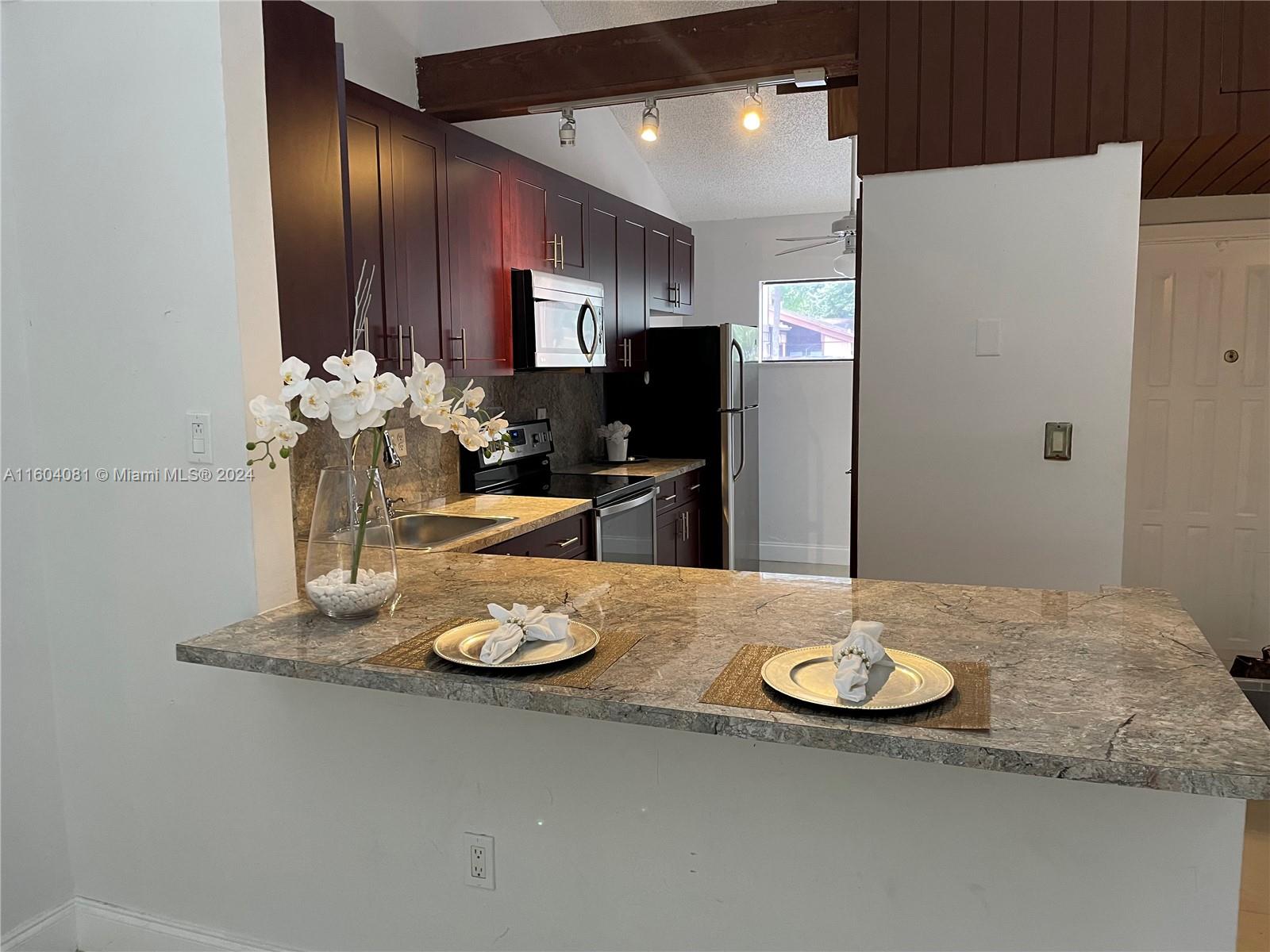 a kitchen with a refrigerator and a stove