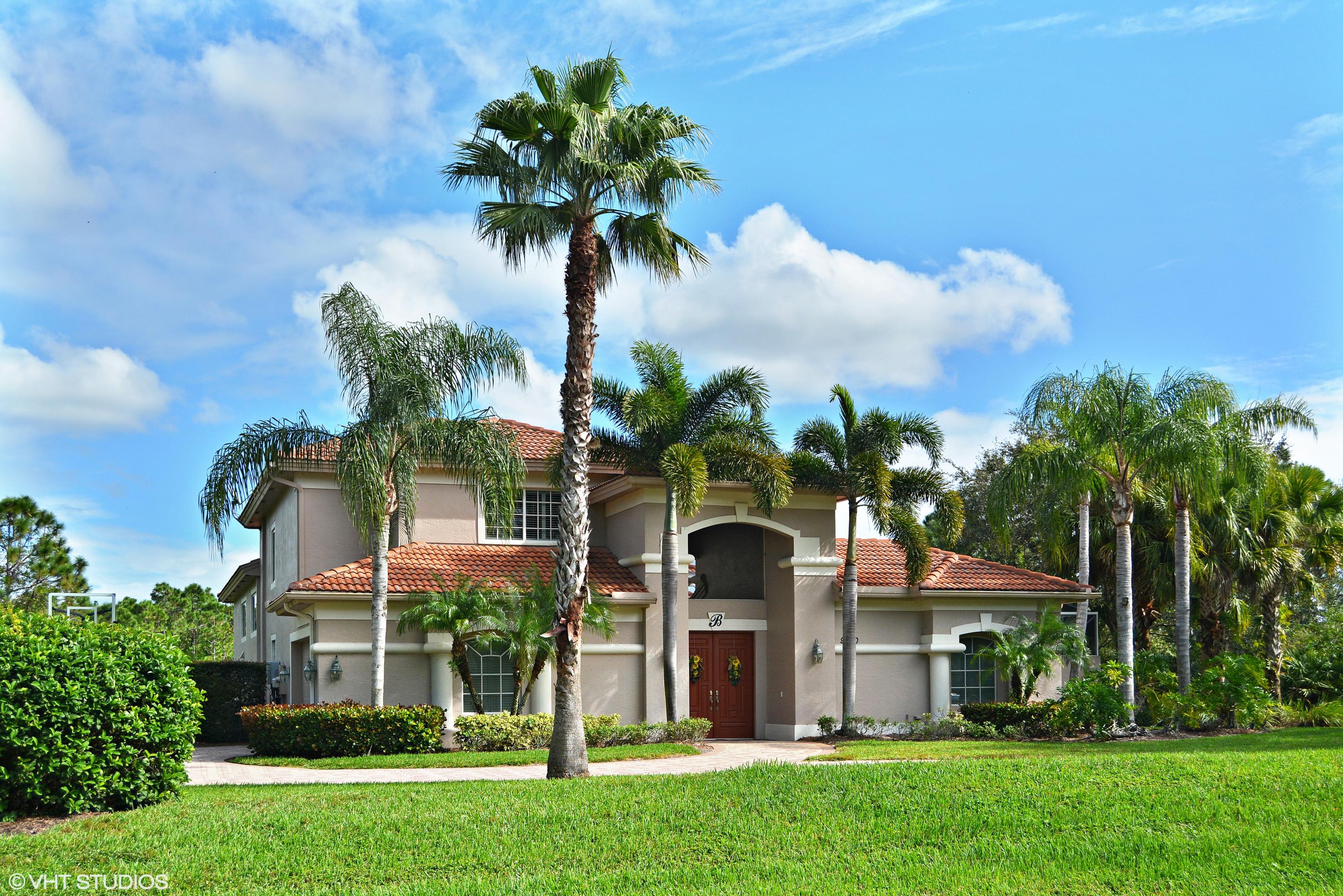 a front view of a house with a yard and fountain in middle