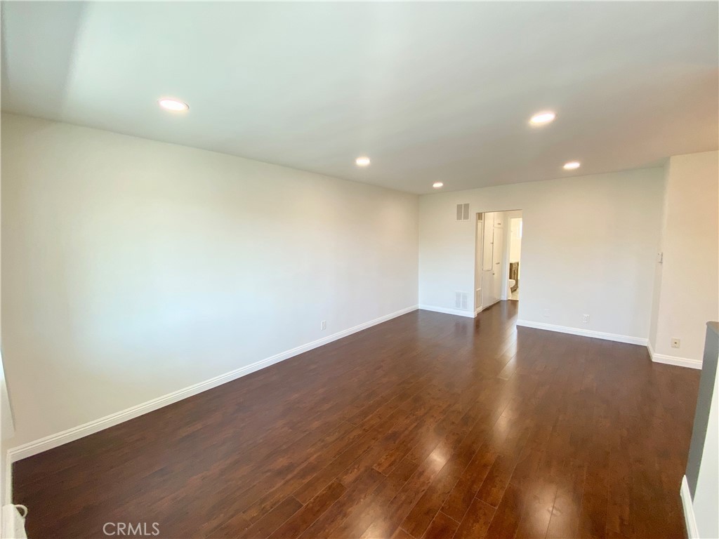 a view of an empty room with wooden floor