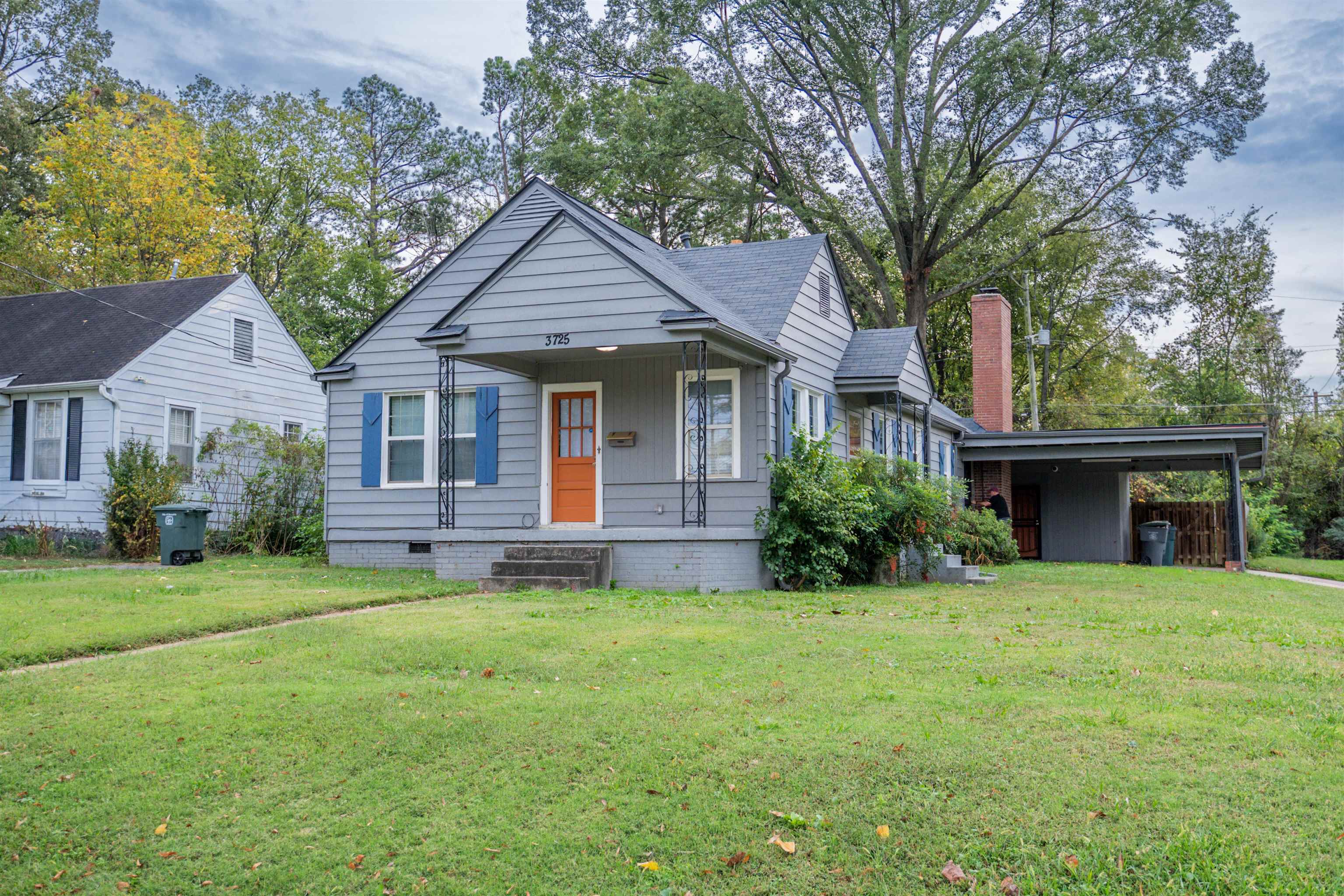 a front view of a house with a yard and trees