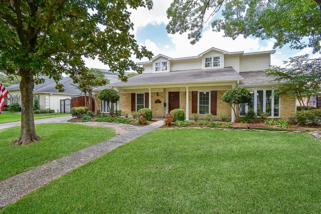 a front view of a house with a yard and trees