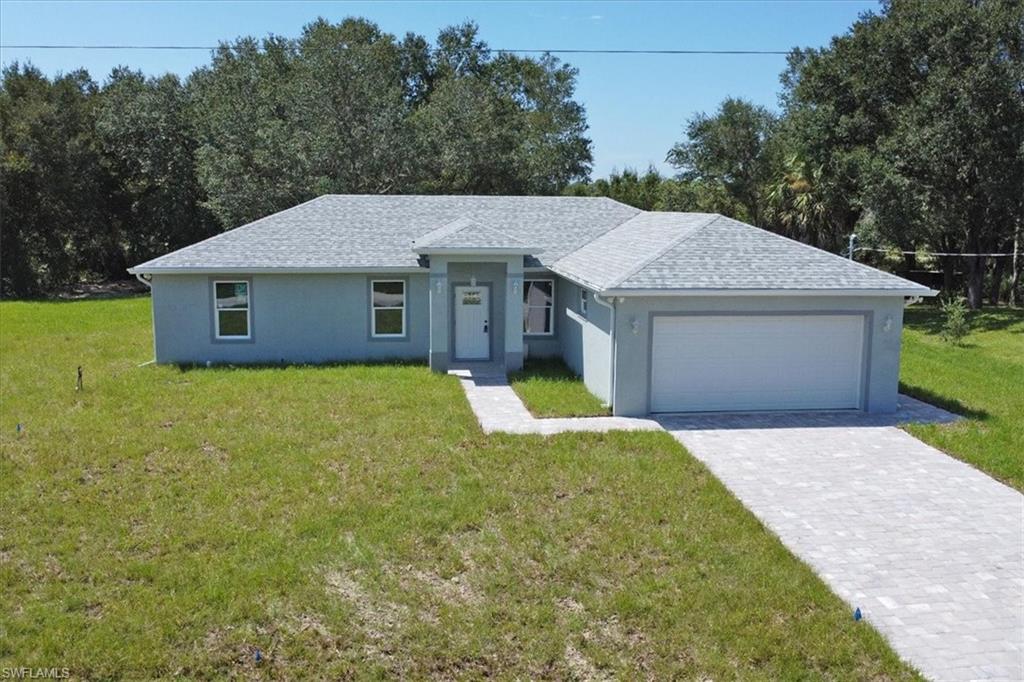 Ranch-style home with a front lawn and a garage