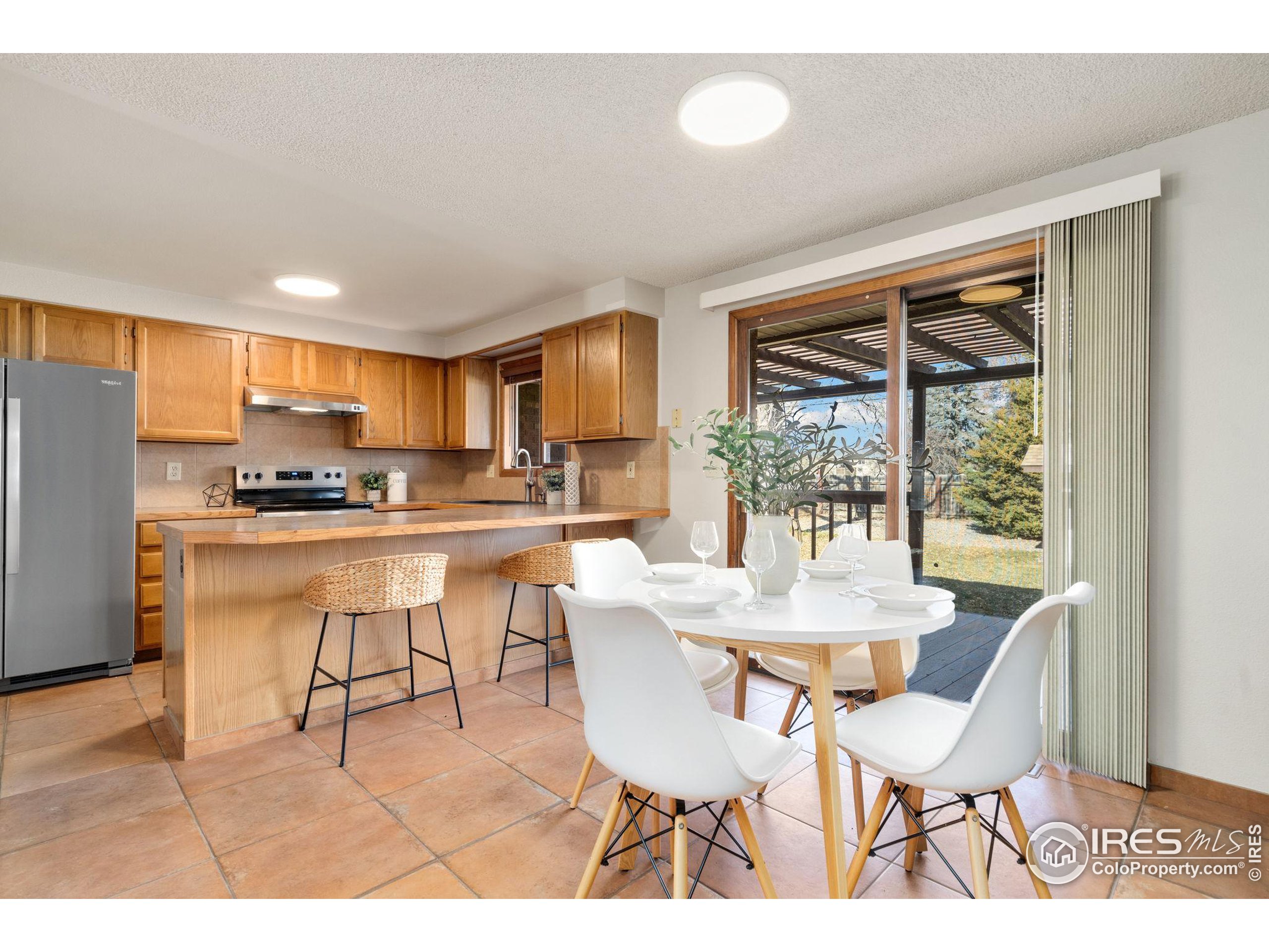 a dining room with furniture a large window and kitchen view