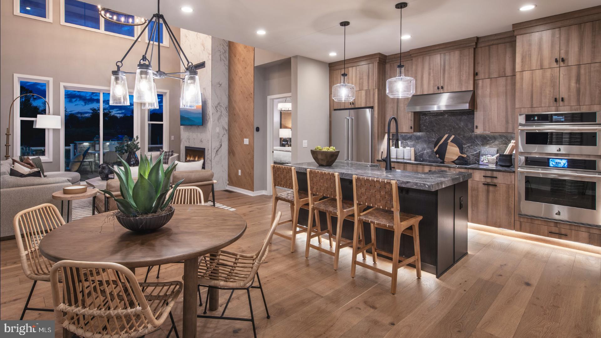 a kitchen with stainless steel appliances kitchen island granite countertop a dining table chairs and sink