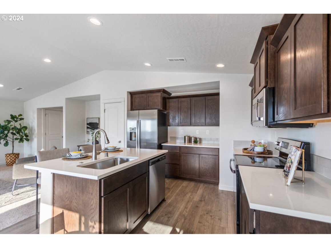 a kitchen with stainless steel appliances granite countertop a sink stove and refrigerator