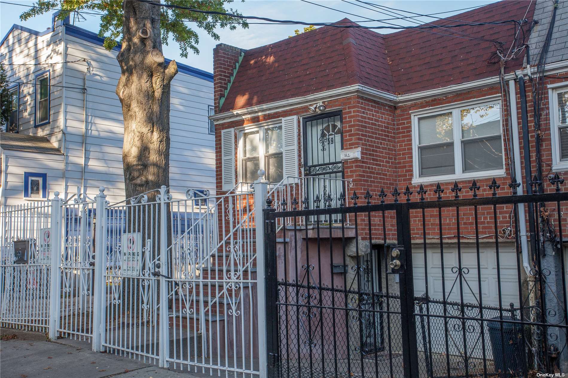 a view of a brick house with iron fence