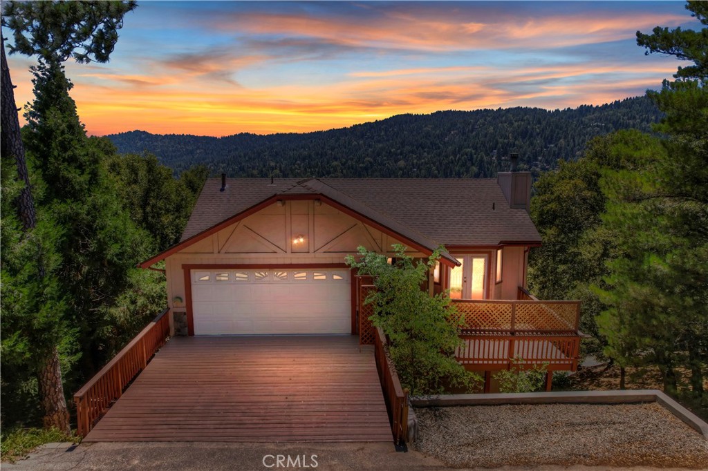 a front view of a house with a yard and mountain view