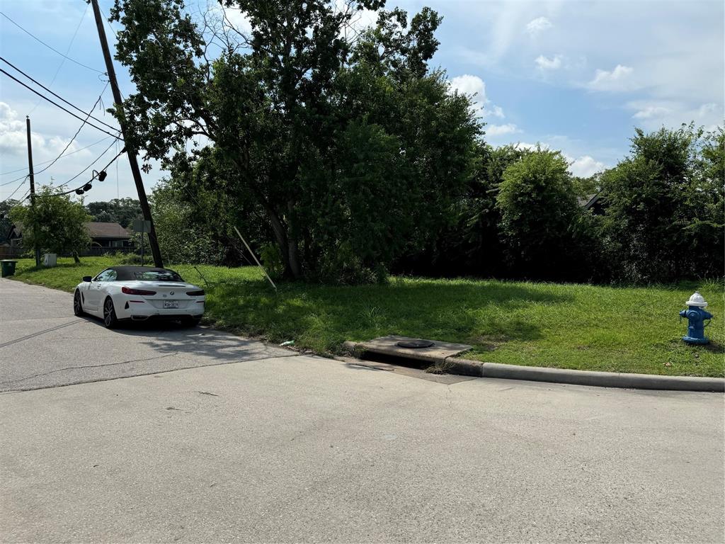 a view of a street with a car parked on the road