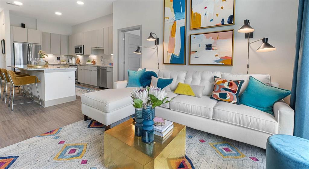 a living room with furniture and a dining area with kitchen view