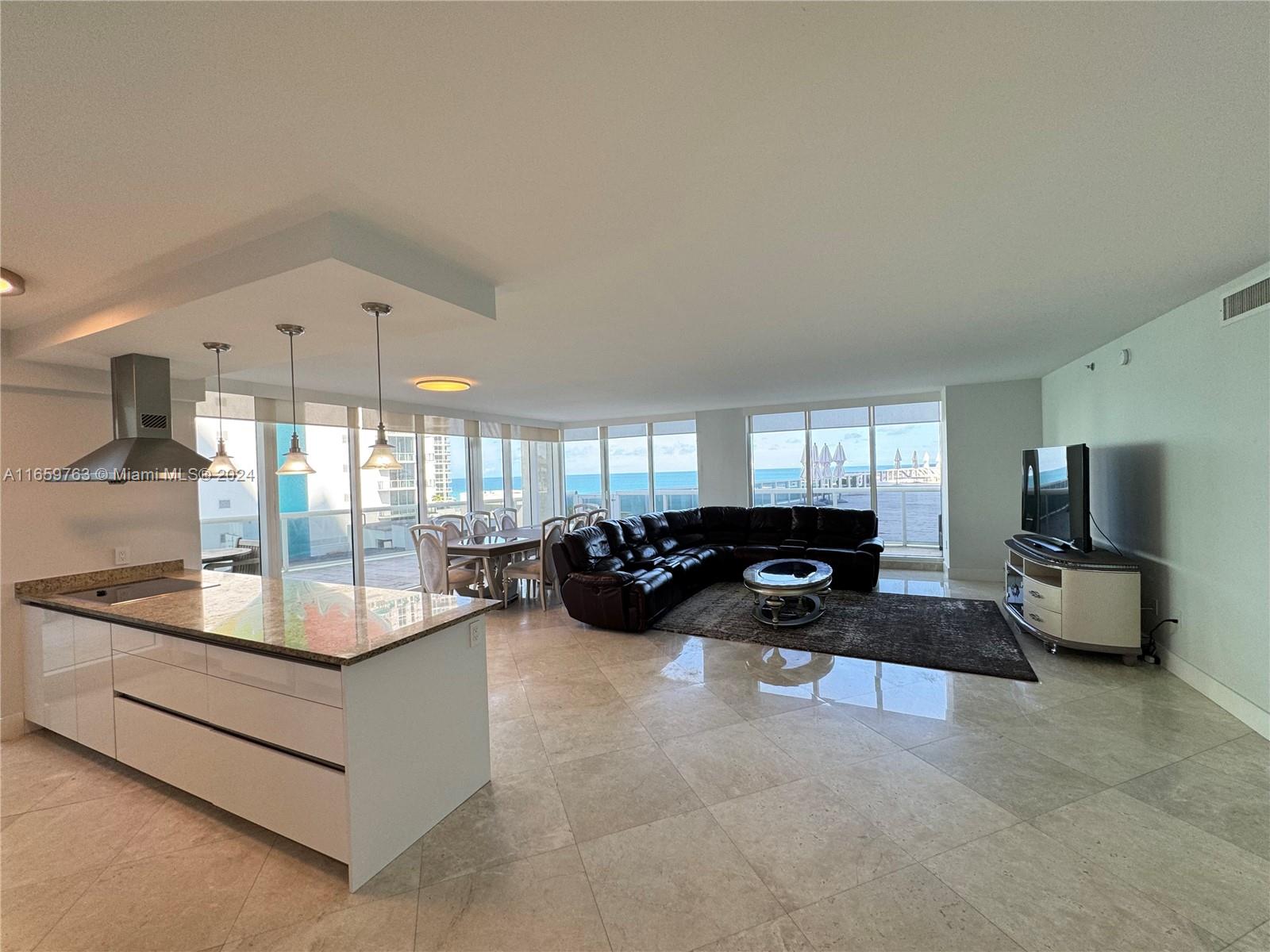 a living room with furniture a flat screen tv and a large window