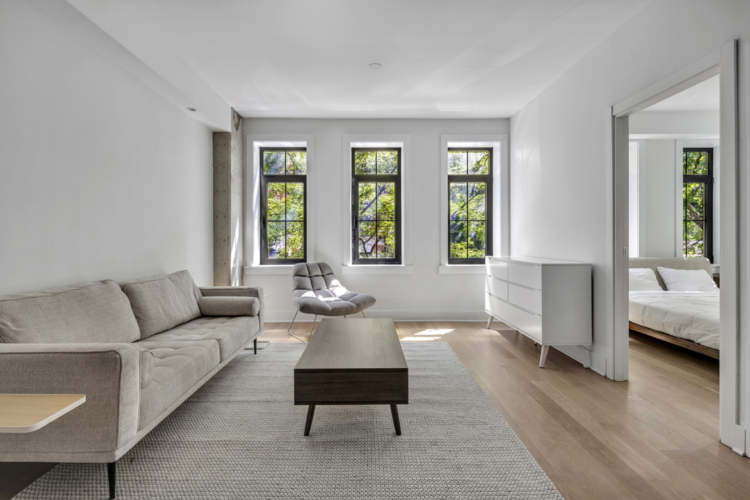 a living room with furniture and two large window