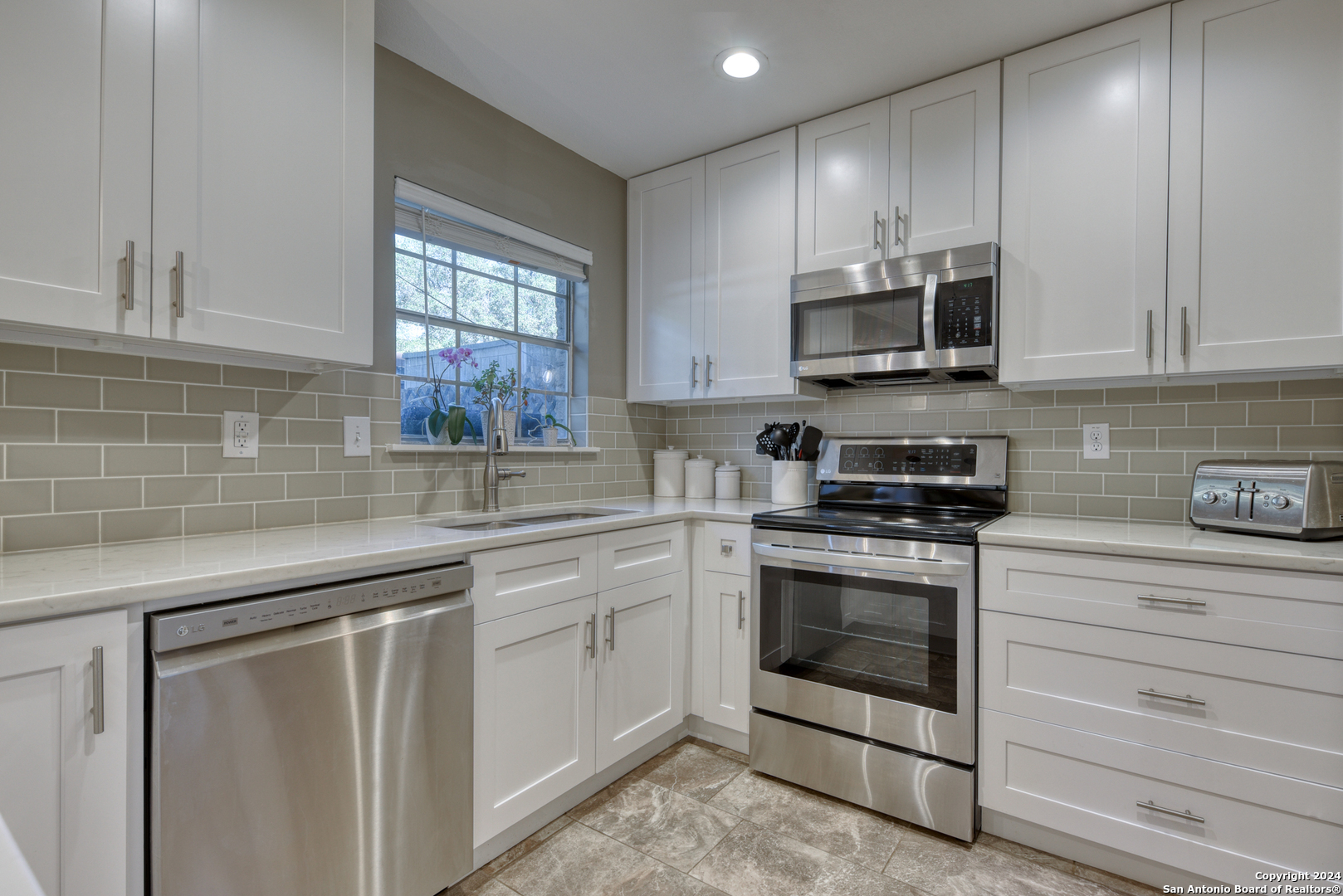 a kitchen with stainless steel appliances granite countertop a sink a stove and microwave