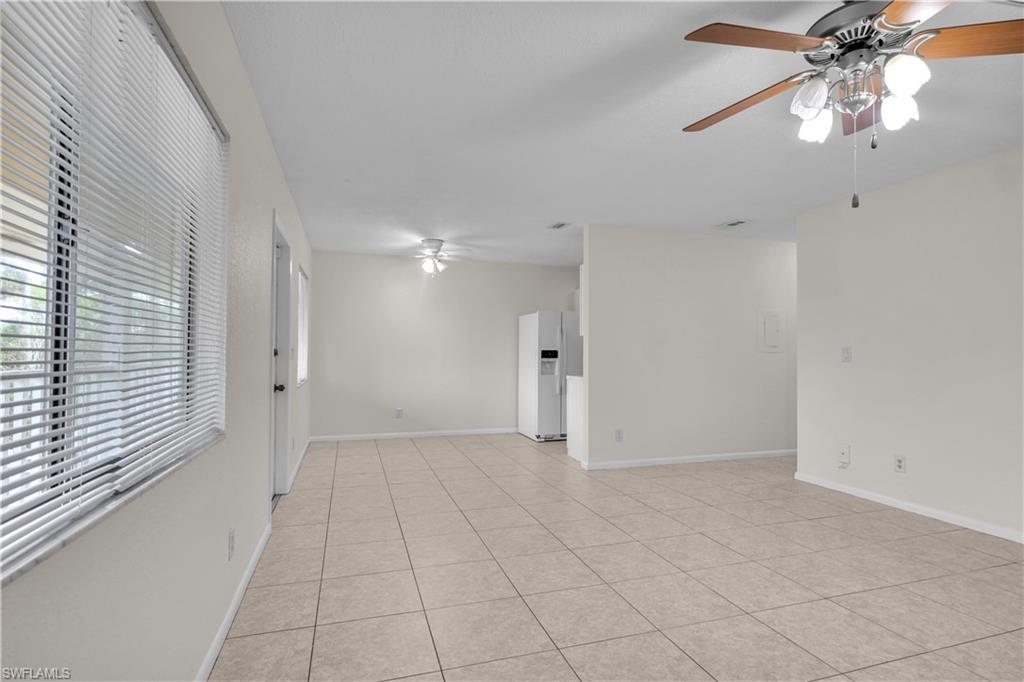 an empty room with a ceiling fan and a window