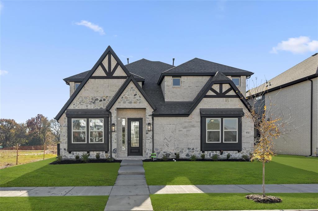 a front view of a house with a garden and yard