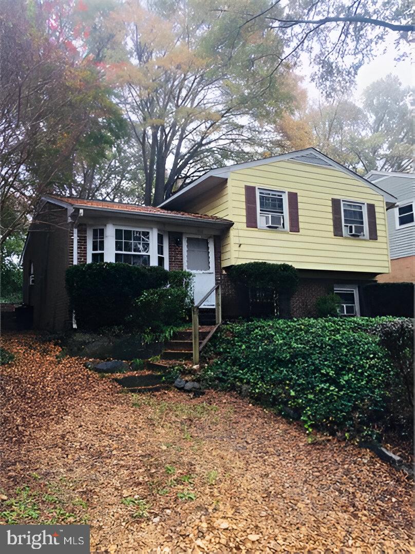 a front view of a house with a yard and green space