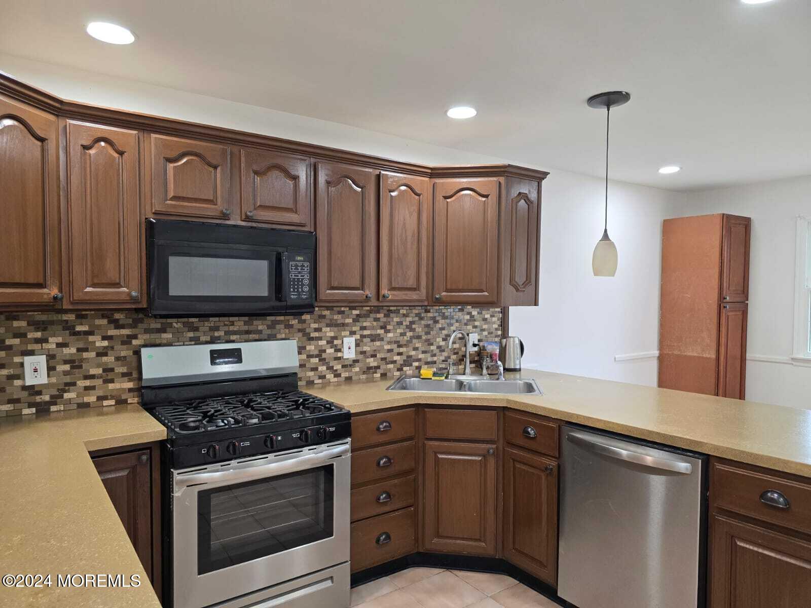 a kitchen with stainless steel appliances a stove a sink and a microwave