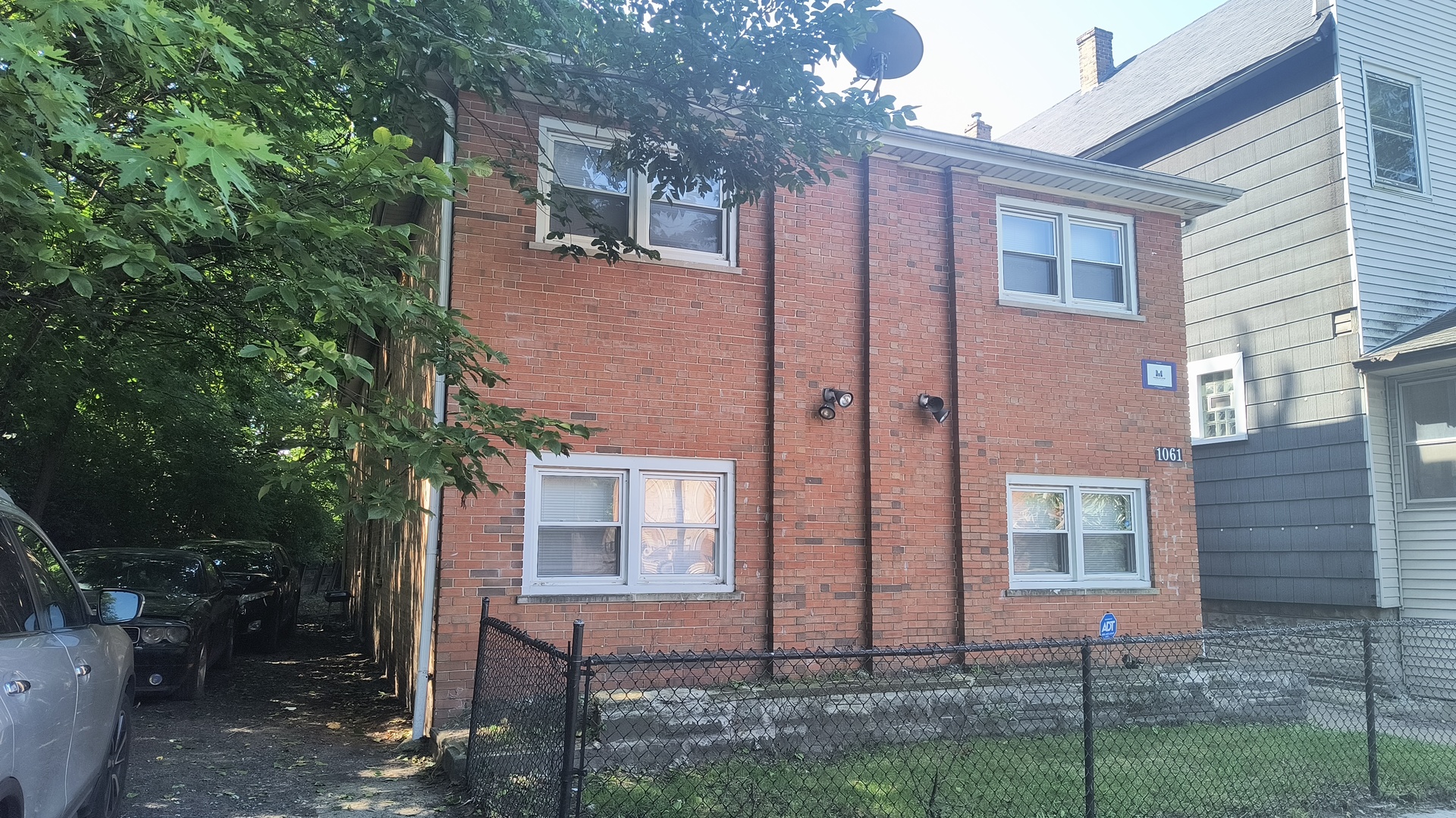 a view of a brick house next to a yard