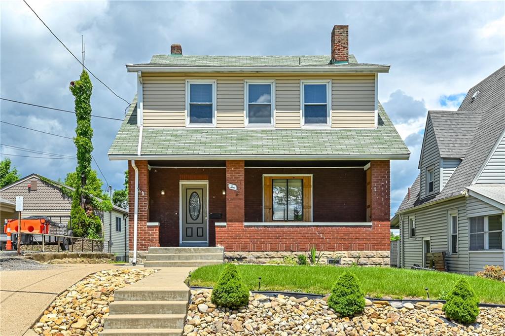 a front view of a house with a yard and potted plants