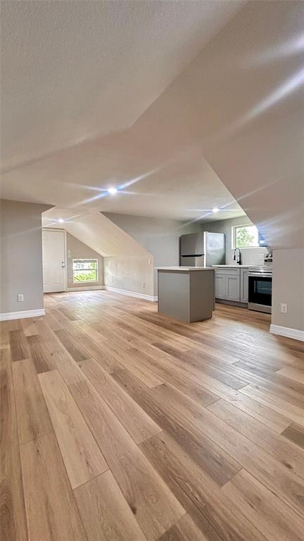 a view of empty room with kitchen and window