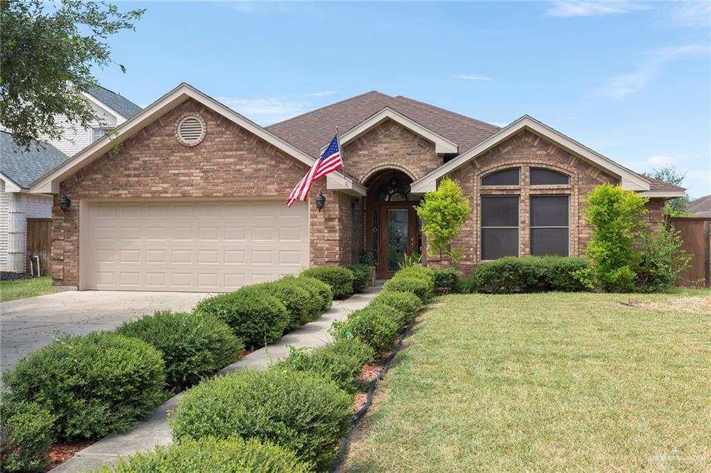 View of front of home with a garage and a front lawn