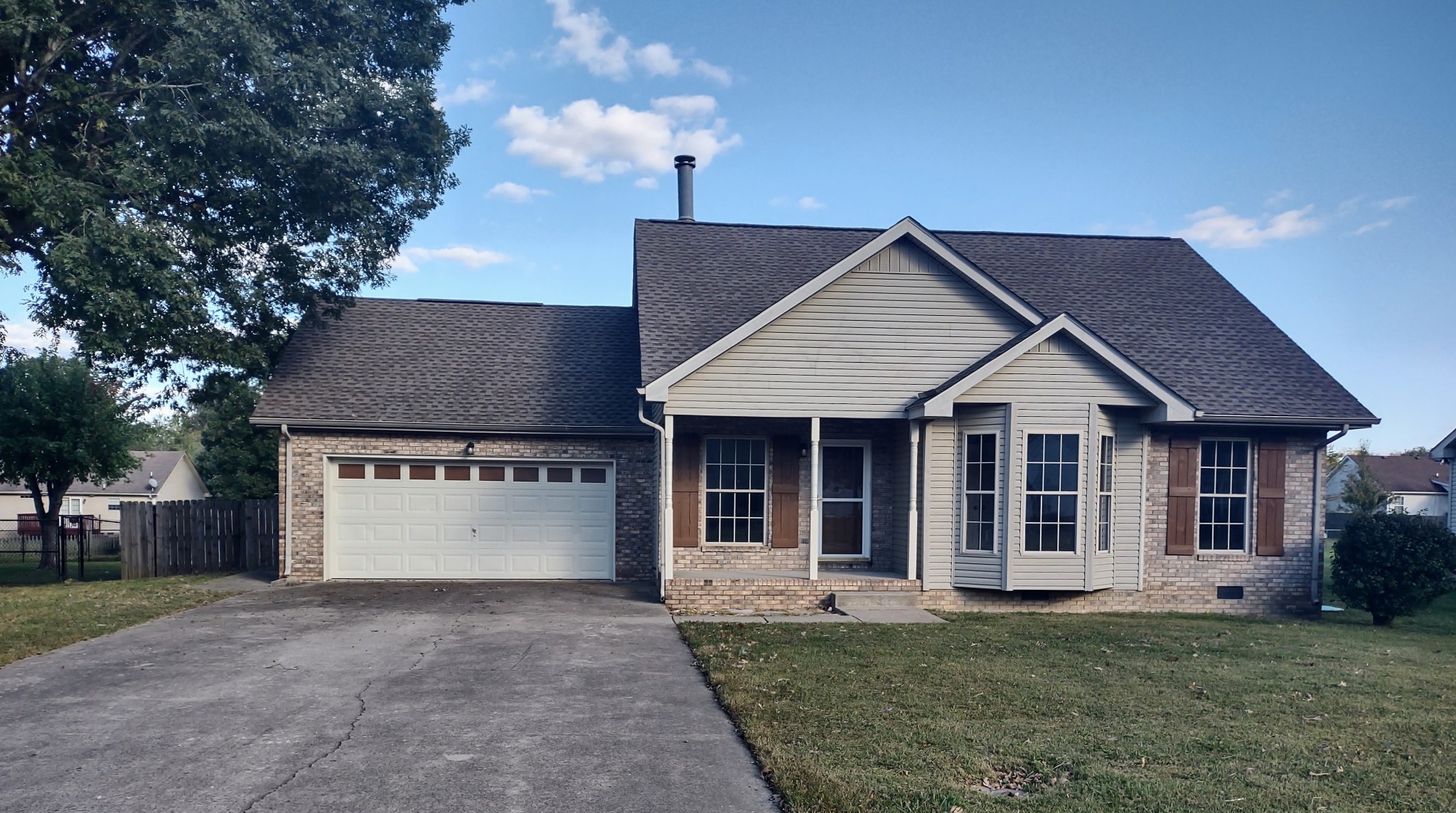 a front view of a house with a garden and yard