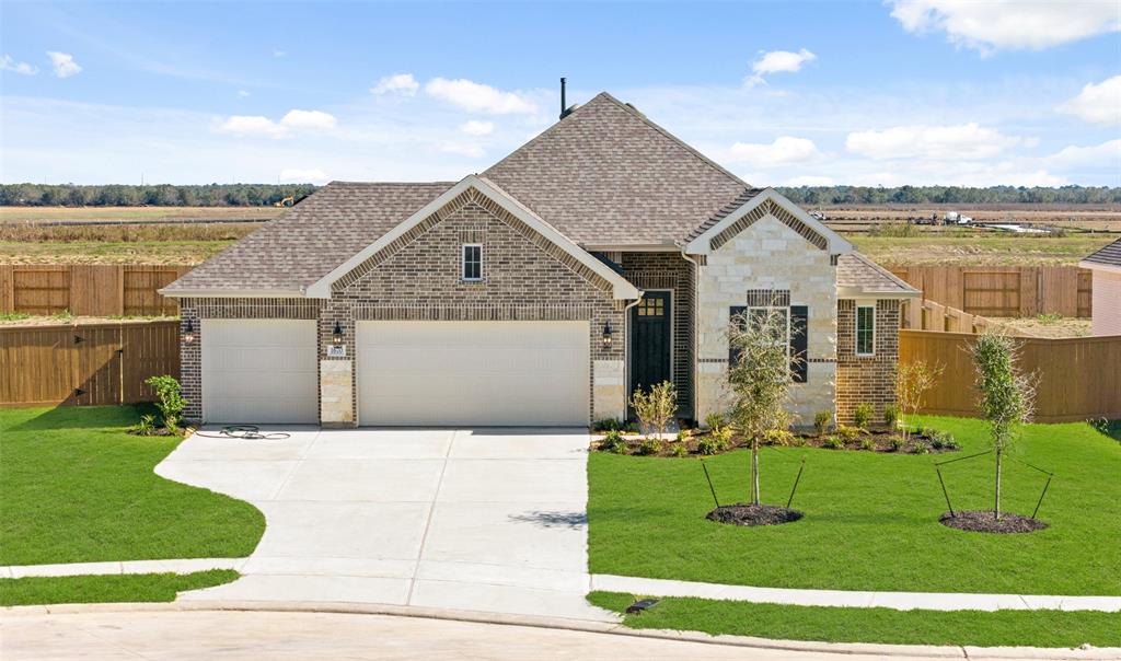 a front view of a house with a garden and yard