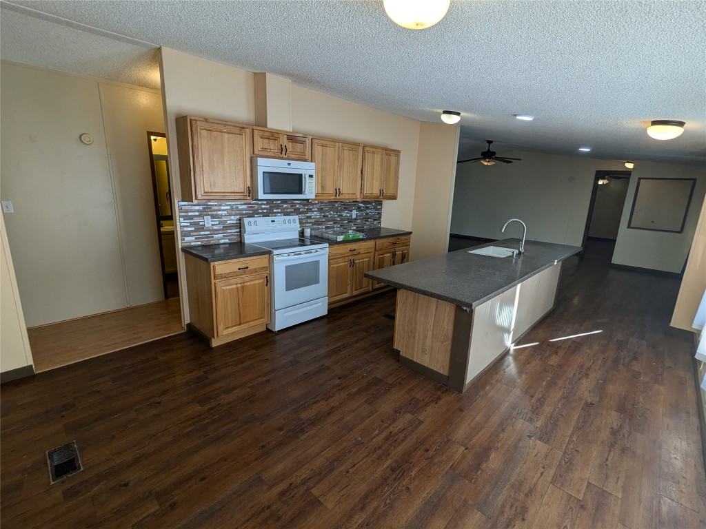 a kitchen with stainless steel appliances granite countertop a sink stove and wooden floor