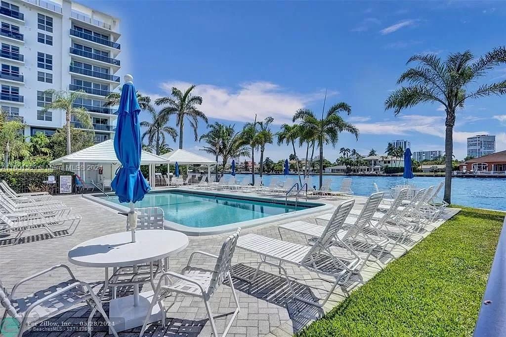 a view of a swimming pool with outdoor seating and plants