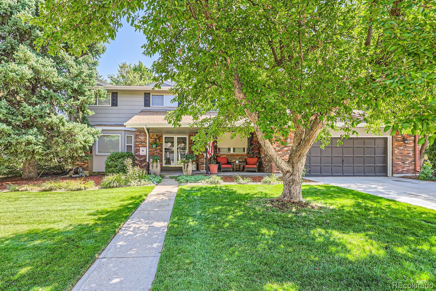 a front view of a house with a yard and trees