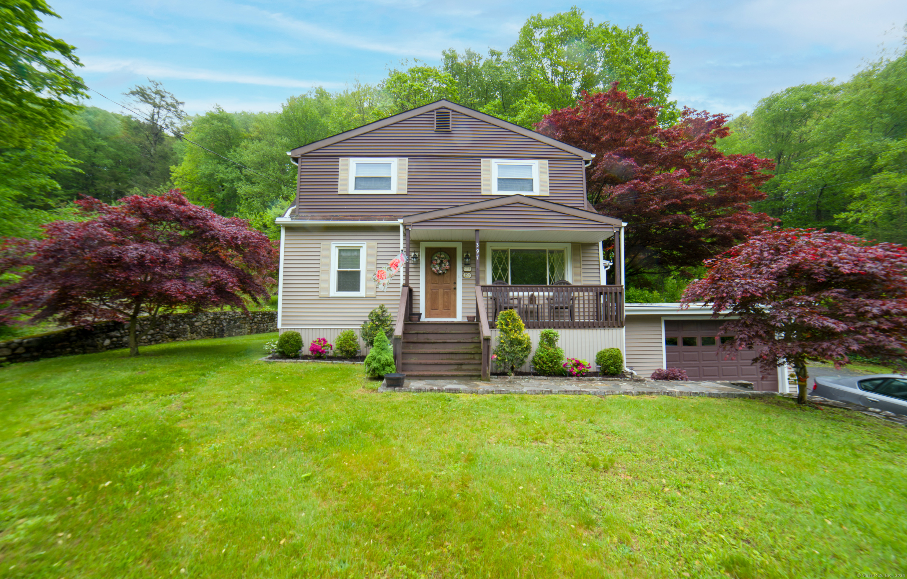 a front view of a house with a yard and trees