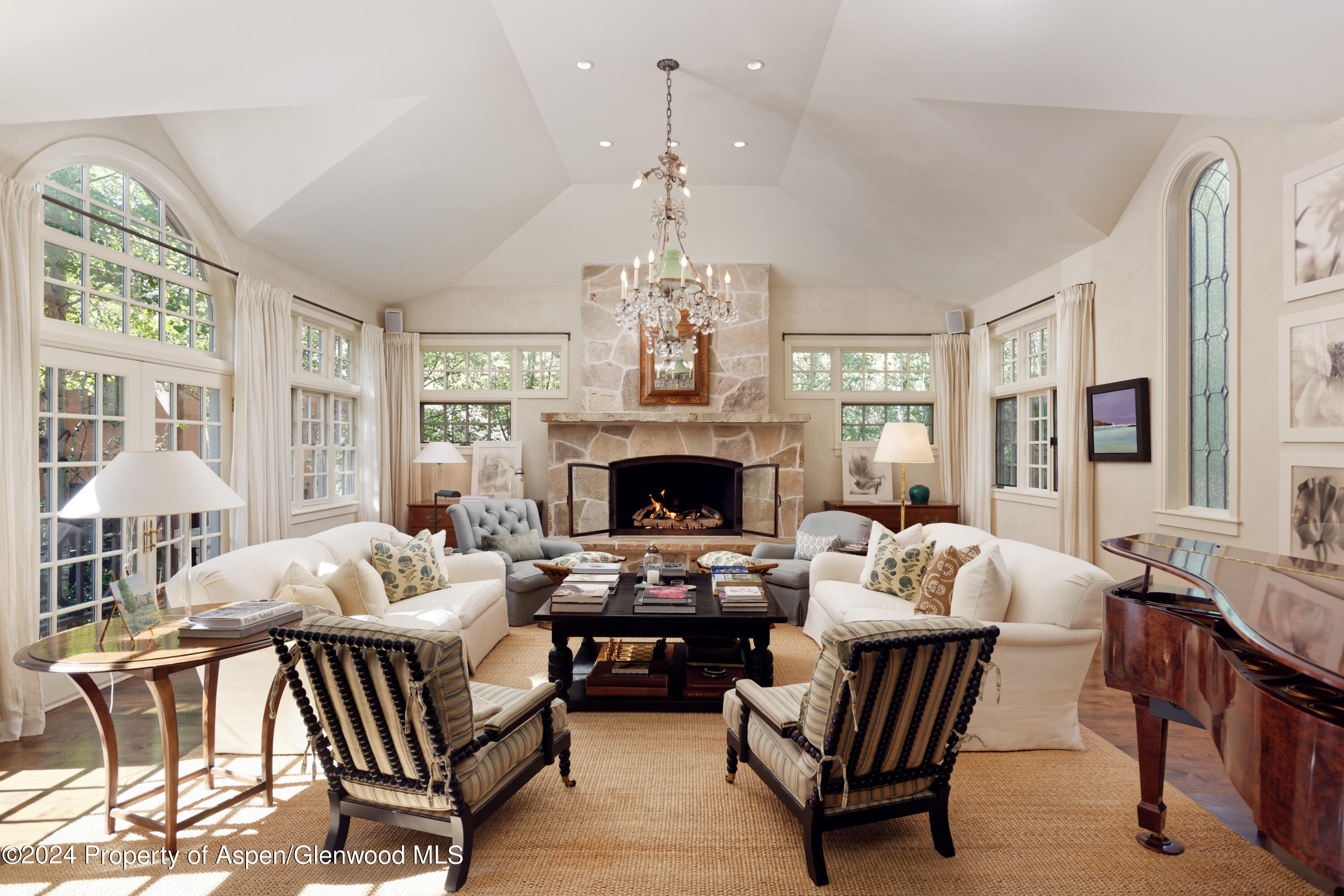 a living room with furniture chandelier and a fireplace