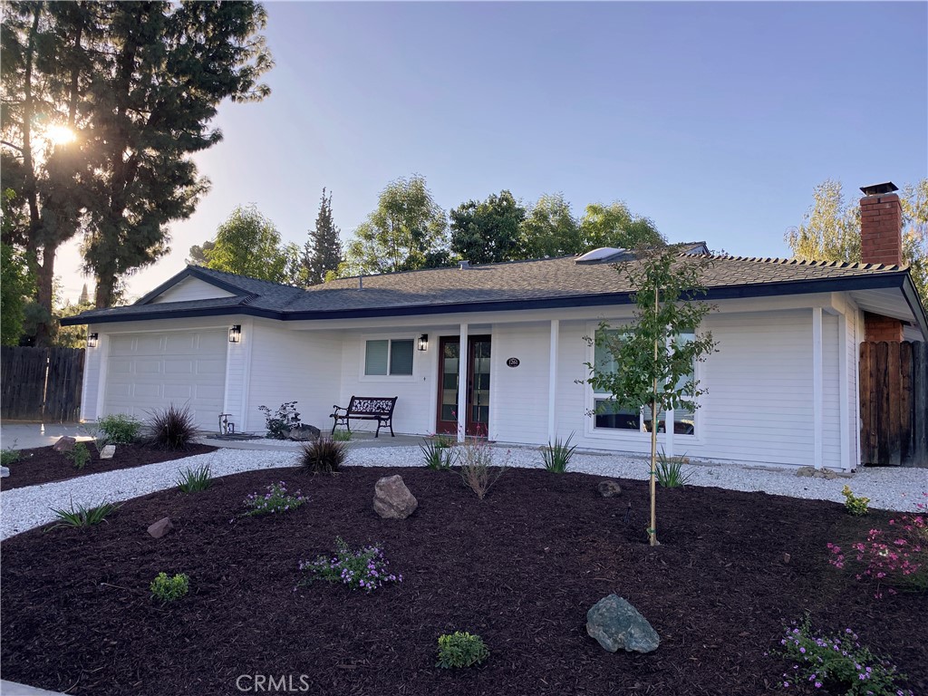 a front view of house with yard and trees in the background