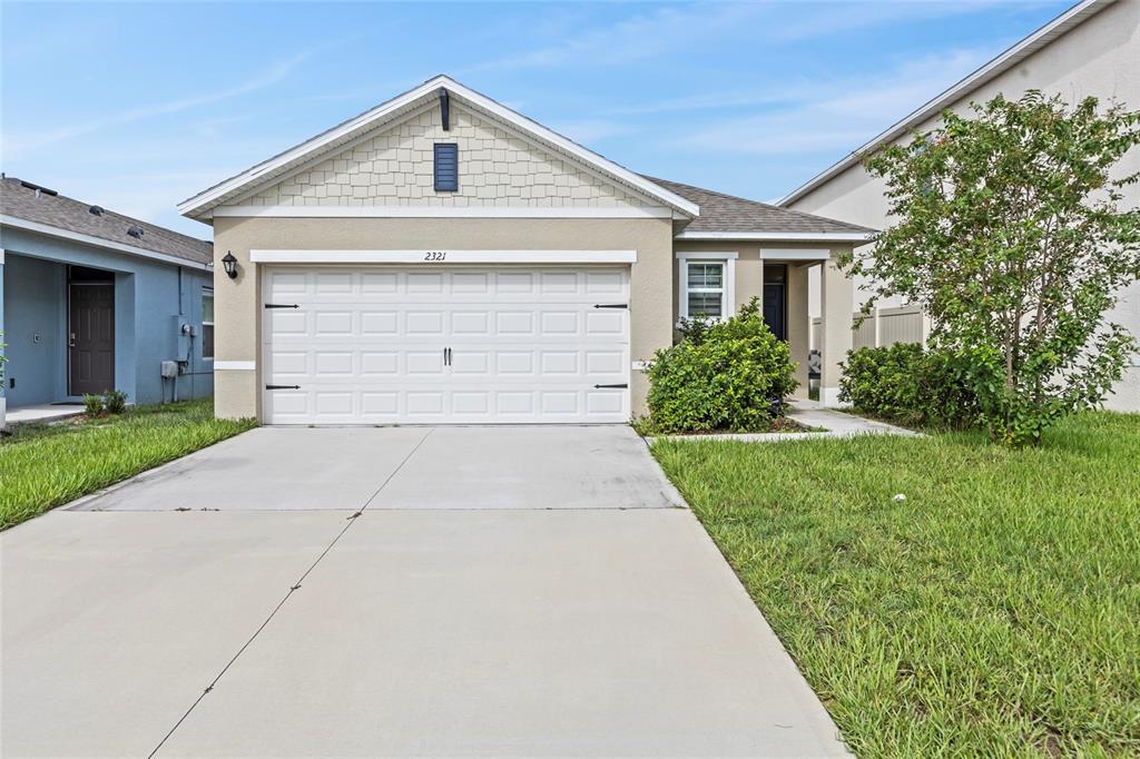 a front view of a house with a yard and garage