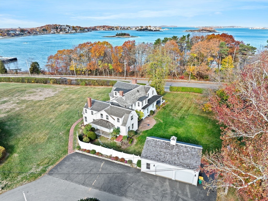 an aerial view of a house with a yard and lake view