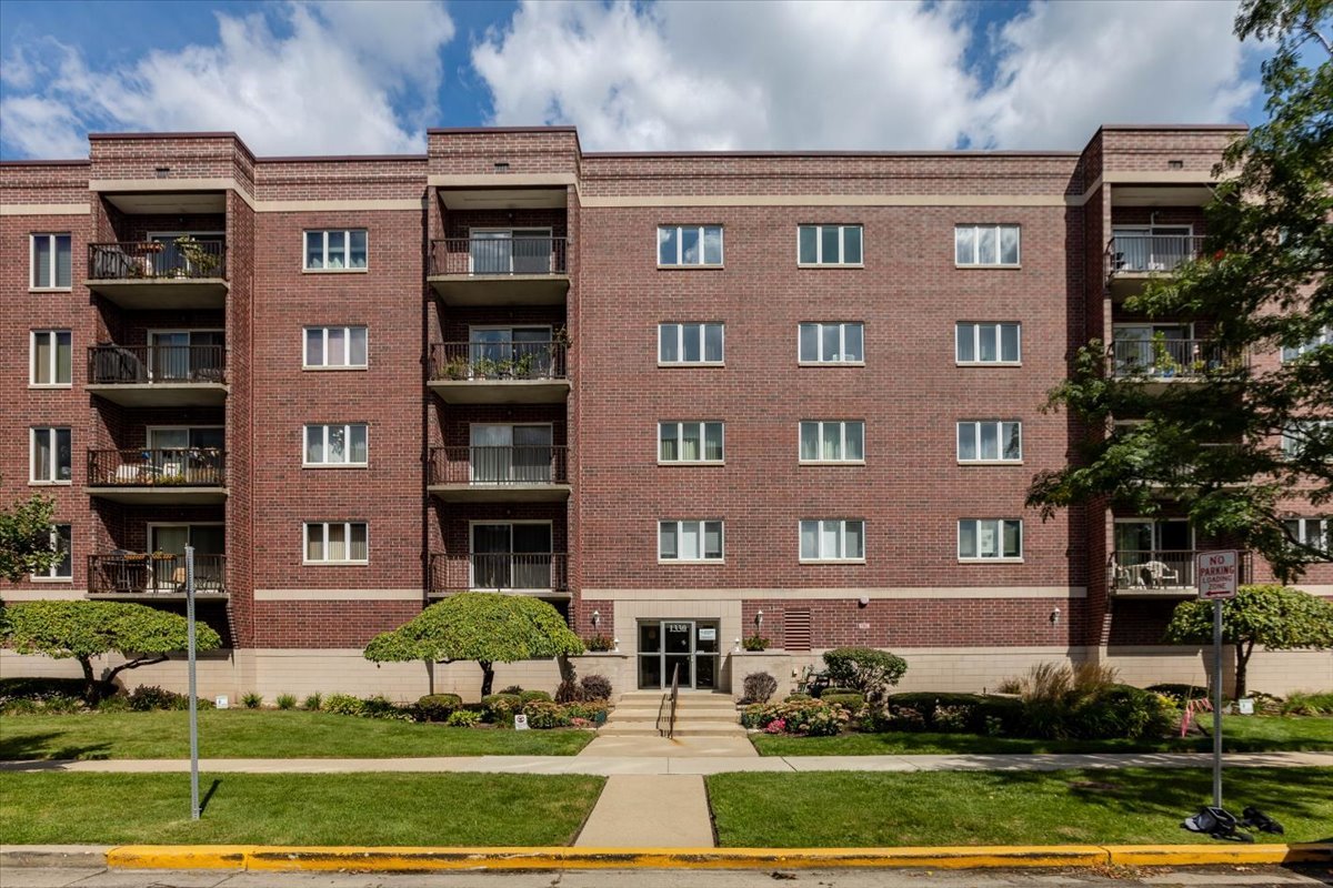 a front view of a residential apartment building with a yard