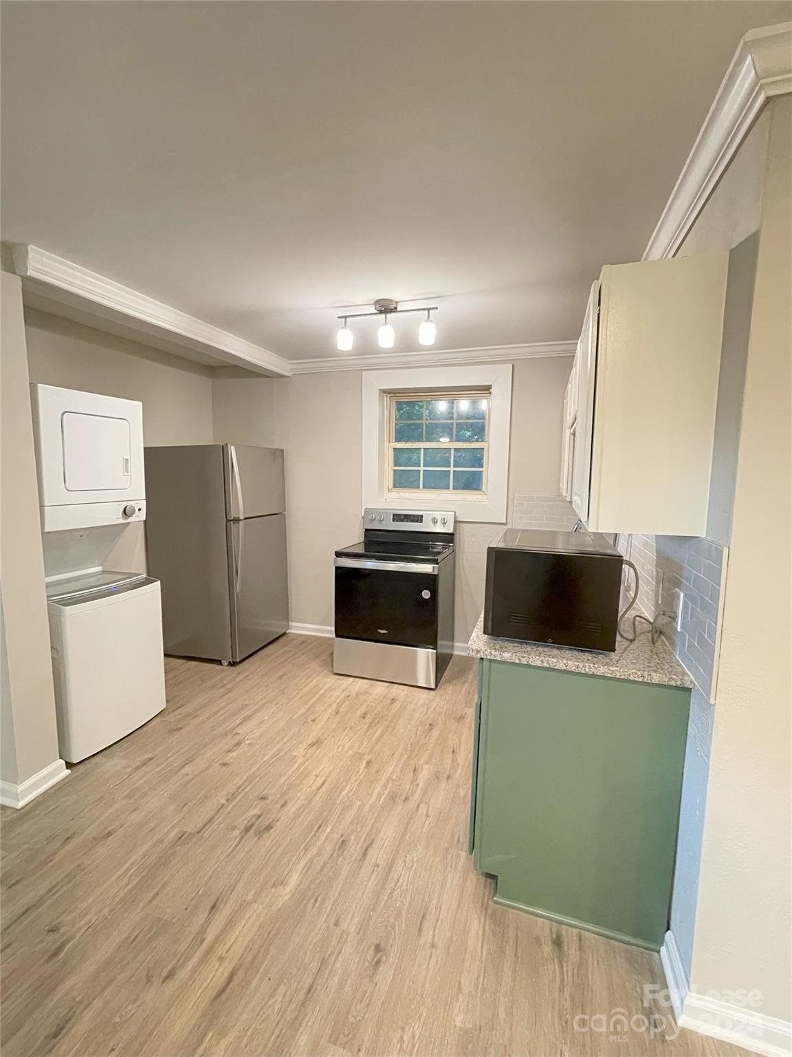 a kitchen with a refrigerator sink and wooden cabinets