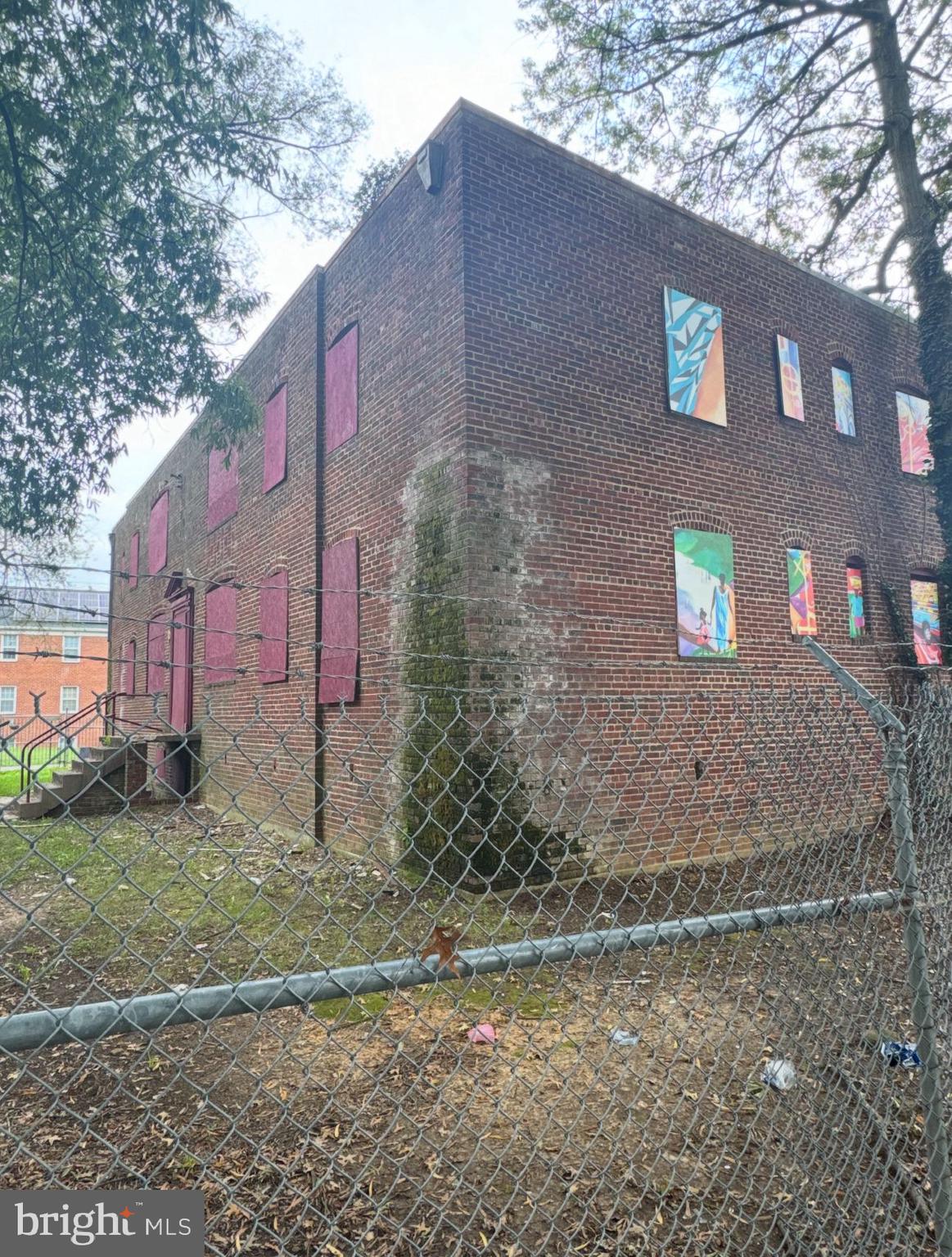 a brick building with a large tree in front of it