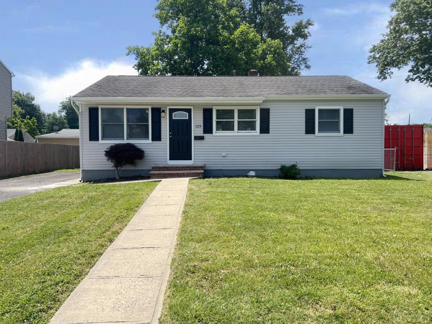 a front view of a house with a yard and potted plants