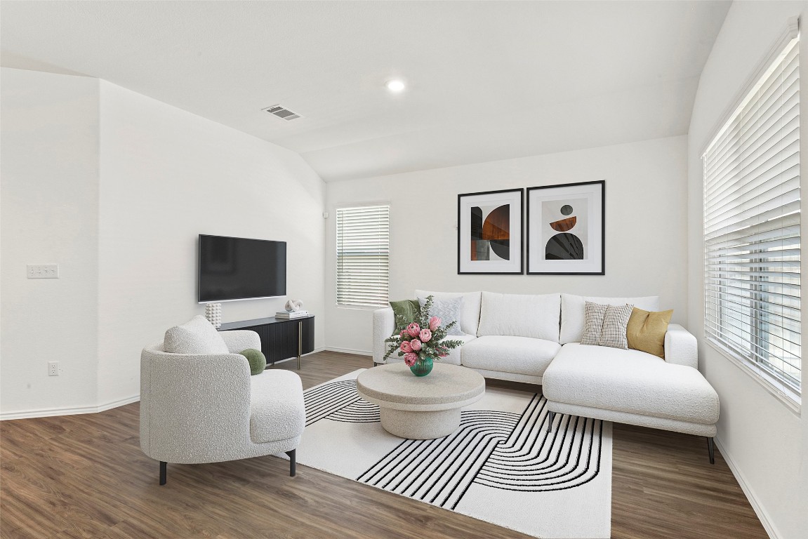 a living room with furniture a rug and a flat screen tv