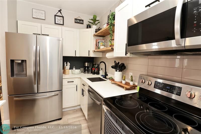 a kitchen with a sink a stove and a refrigerator