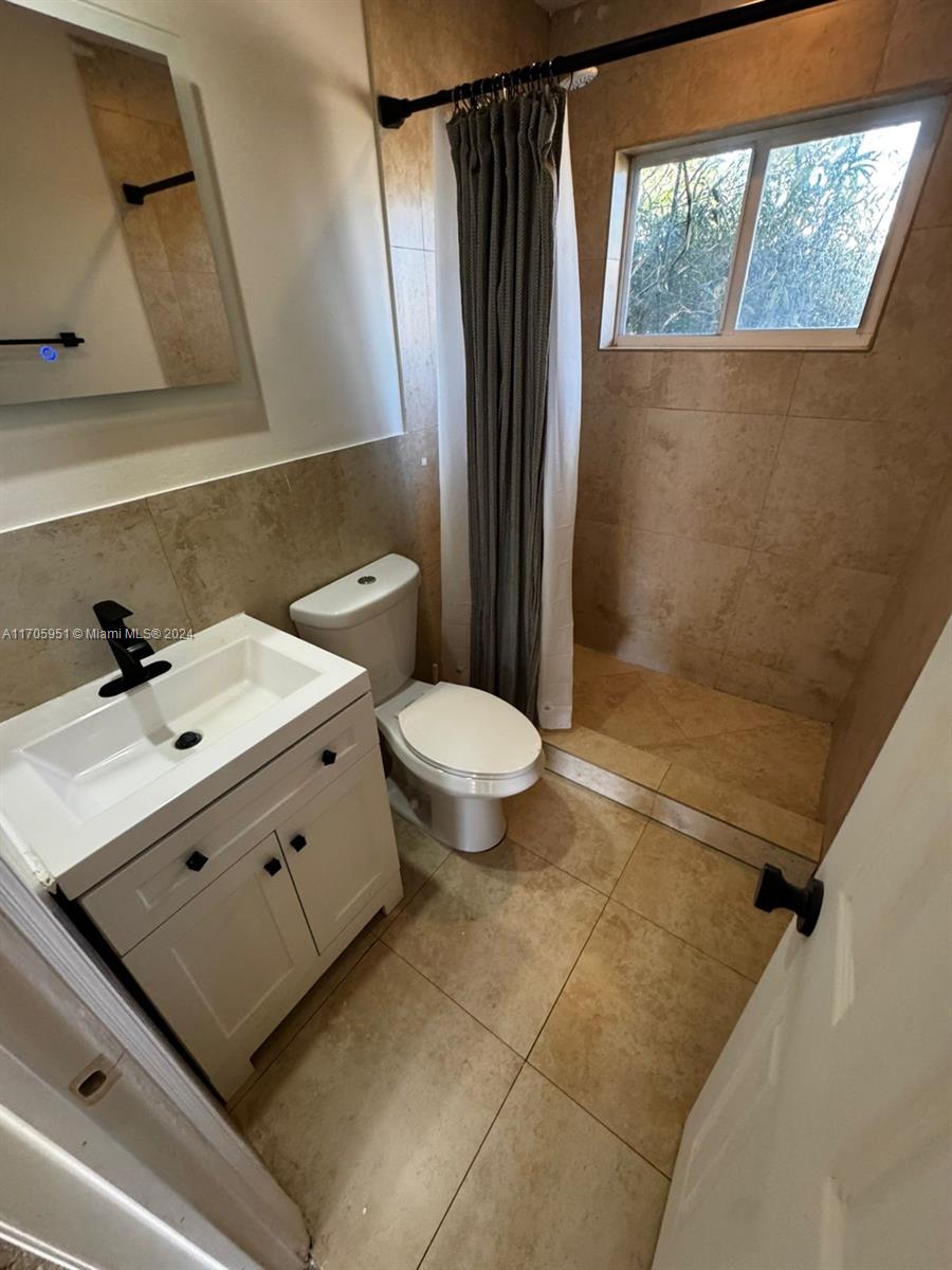 a bathroom with a sink a toilet and shower curtain